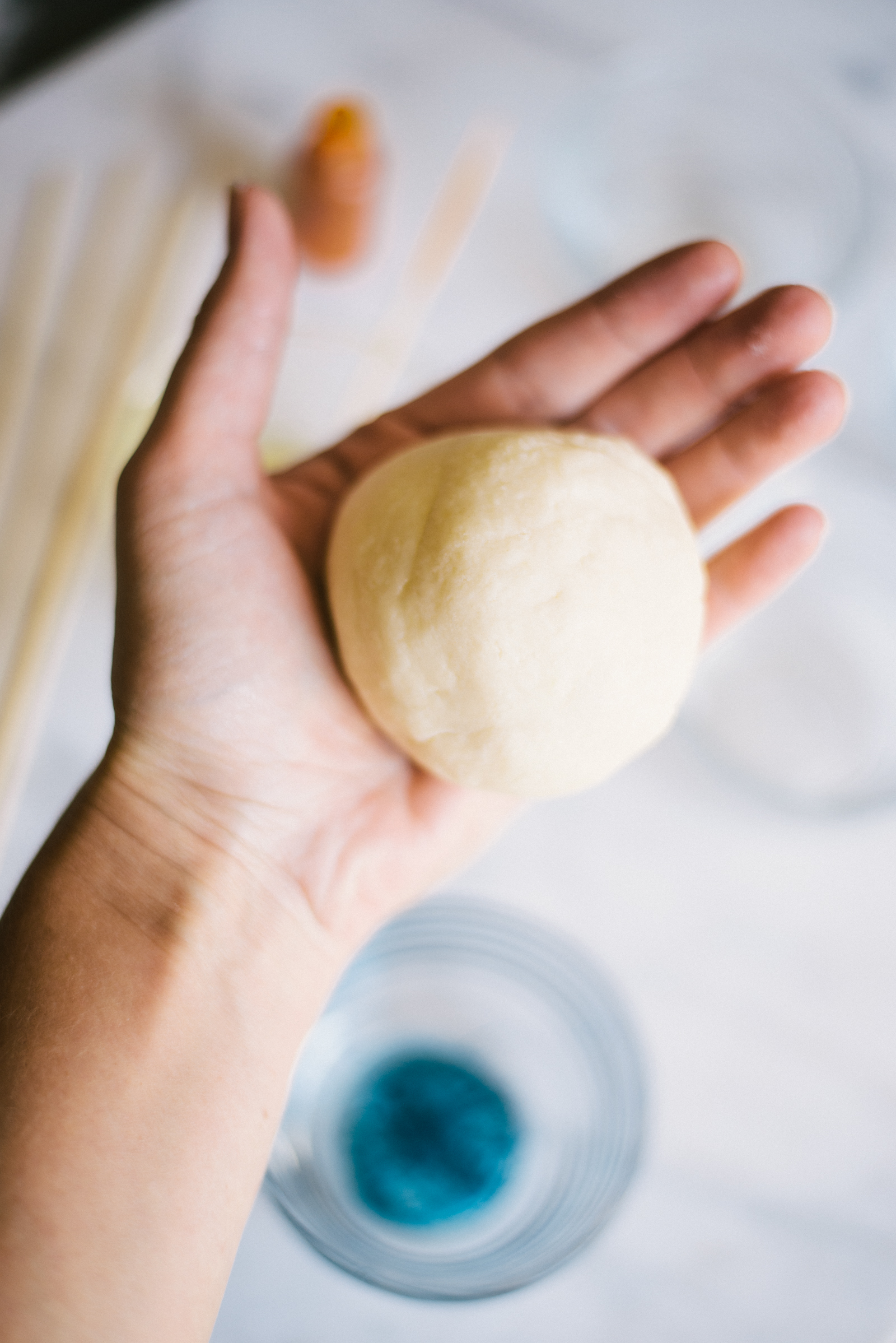 home made play dough rolled into a ball in hand