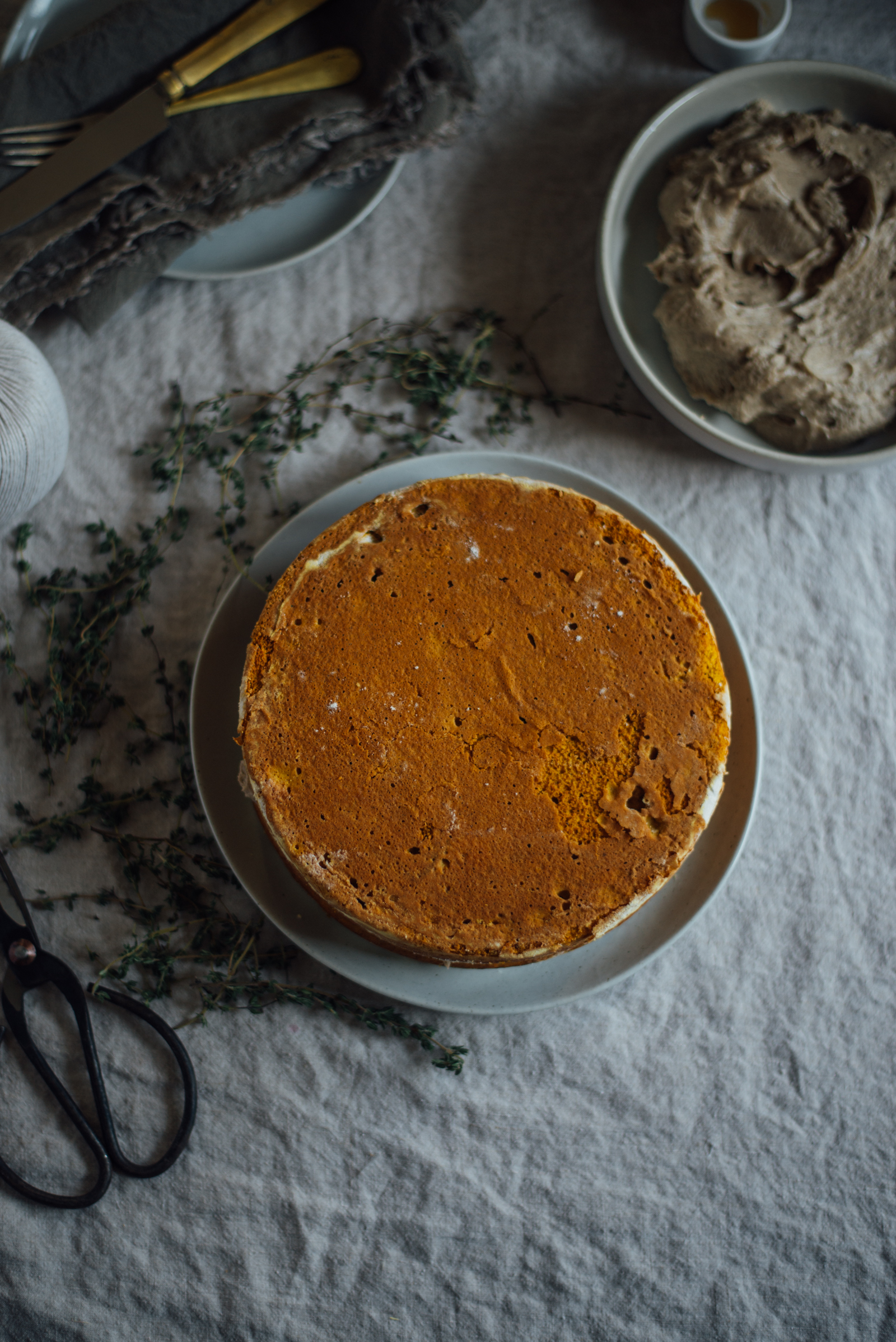 cake on round plate and linen tablecloth with herbs