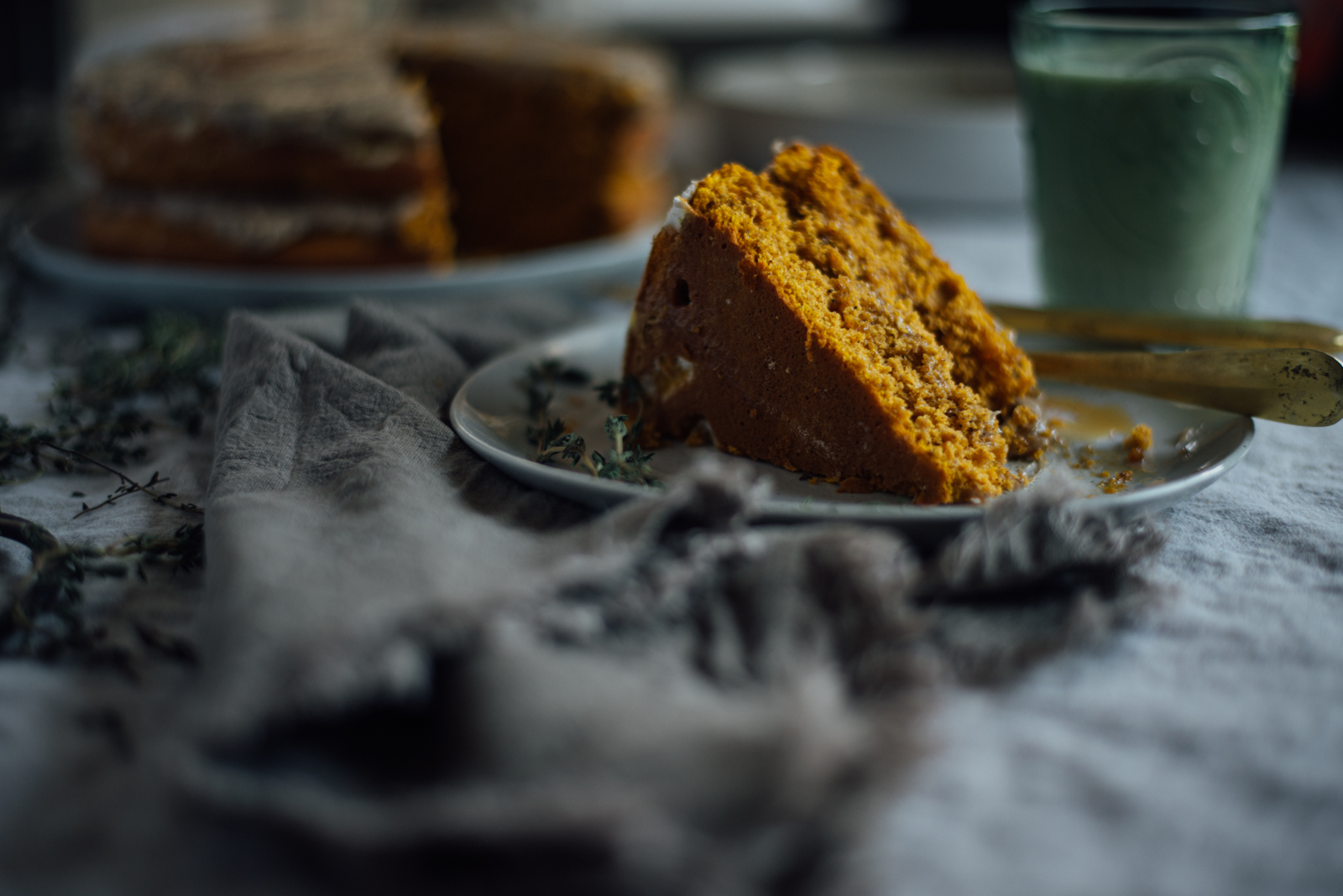 slice of pumpkin cake with browned butter frosting on linen tablecloth