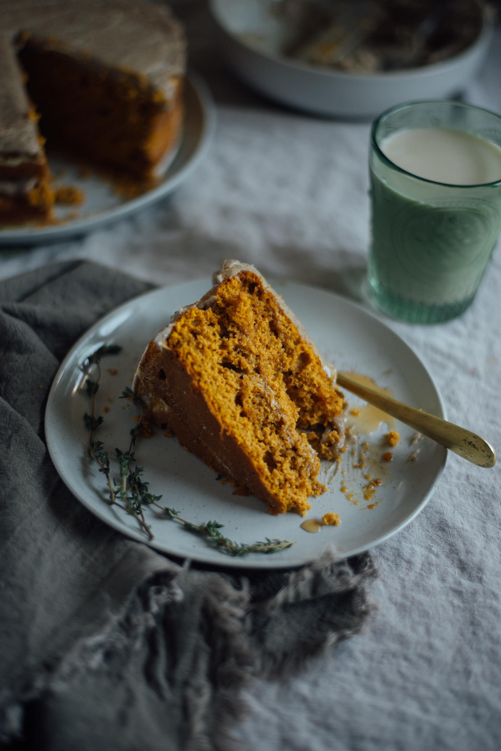 slice of pumpkin cake with browned butter frosting on linen tablecloth