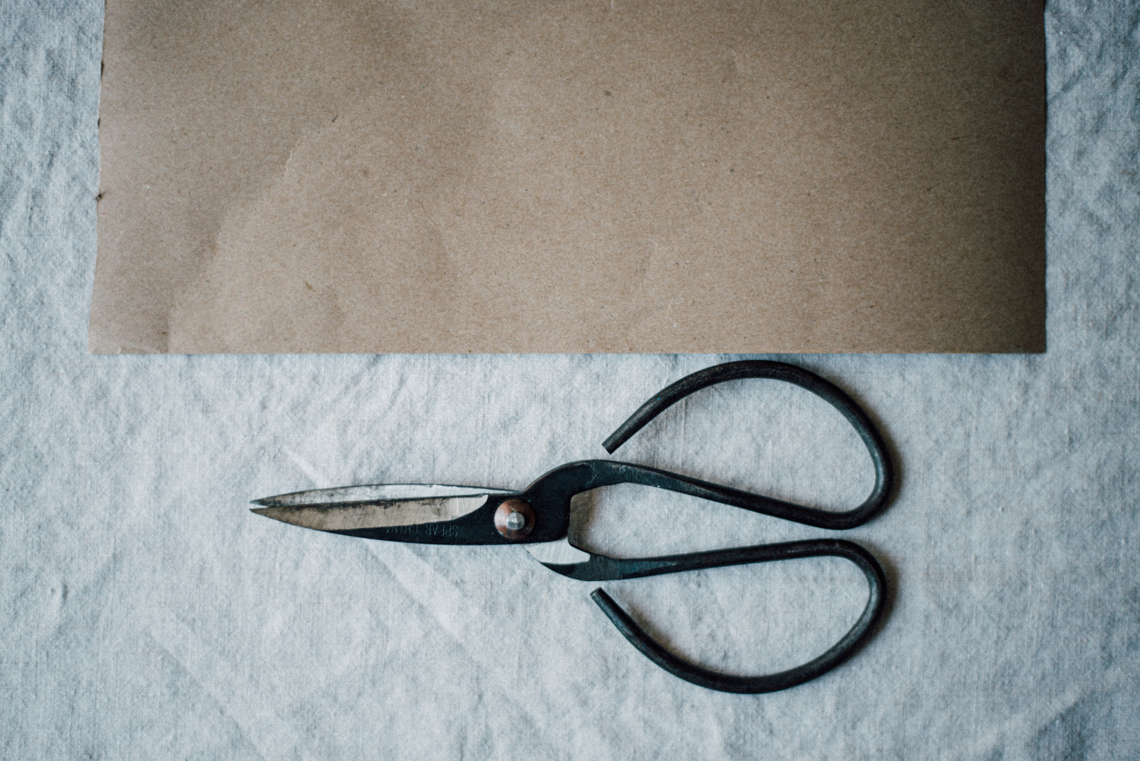 craft paper with metal scissors on linen tablecloth
