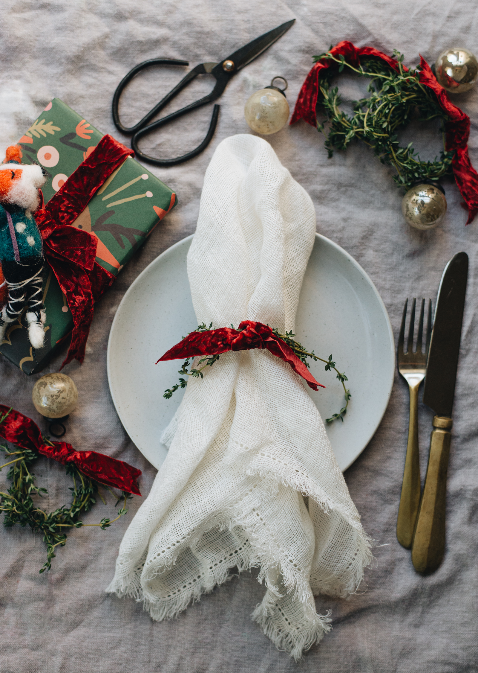 red velvet christmas thyme mini wreath on white dinner plate