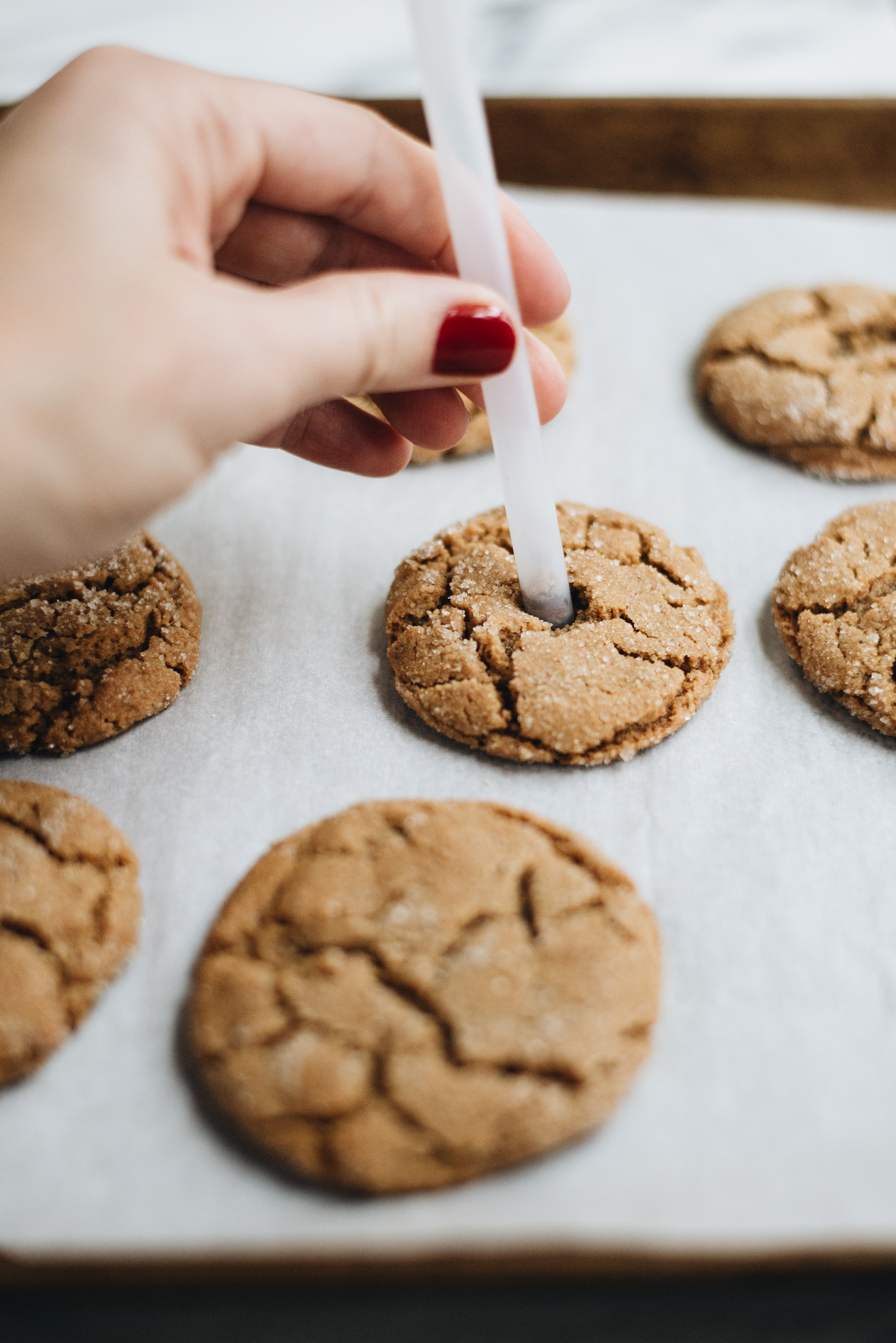 cookies with straws poking the holes in center for milk shooters for kids