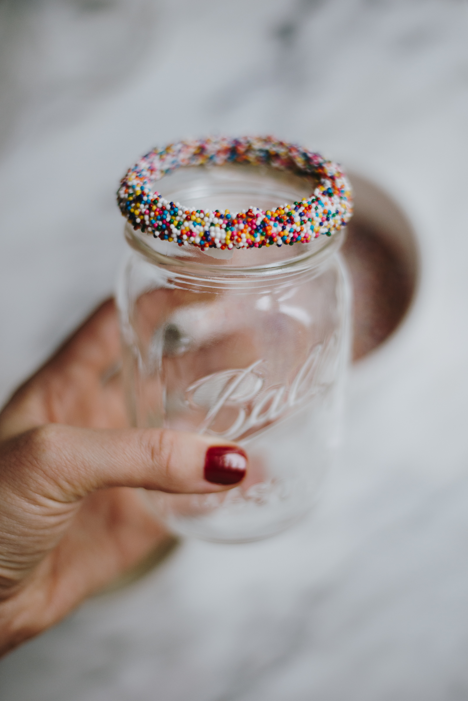 rainbow sprinkles on edge of mason jar glass