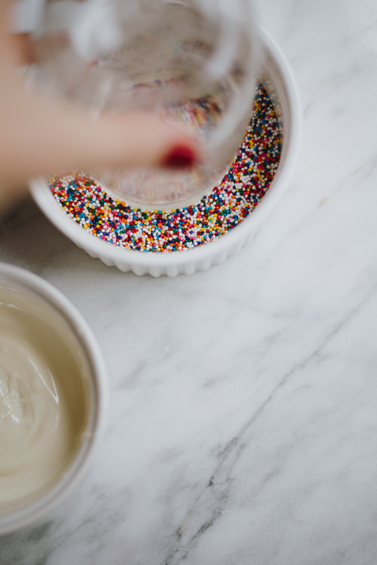 twist melted chocolate rims of mason jars into bowl of rainbow sprinkles